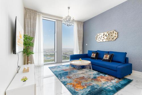 a living room with a blue couch and a large window at Lux BnB I Amna Tower I Panaromic Views in Dubai