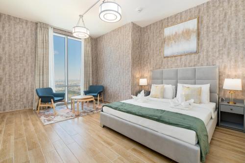 a bedroom with a large bed and two chairs at Lux BnB I Amna Tower I Panaromic Views in Dubai