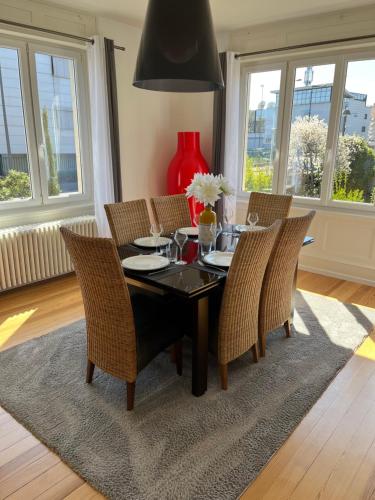 comedor con mesa negra y sillas en Appartement de Prestige au centre avec jardin privé, en Colmar