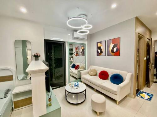 un salon avec un canapé et une table dans l'établissement Vinhomes Smartcity-Căn hộ dich vụ-Zhomestay, à Phú Thú