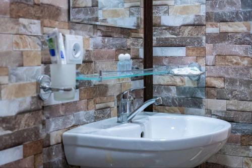 タシュケントにあるHotel & Hostel Galleryのバスルーム(ガラスの棚付きの洗面台付)