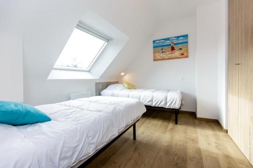 dwa łóżka w pokoju z oknem w obiekcie MAISON NEUVE LUMINEUSE AU CALME PROCHE DES PLAGEs w mieście Quiberon