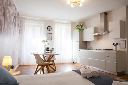 a bedroom with a bed and a kitchen with a table at Appartamento Anastasia in Verona