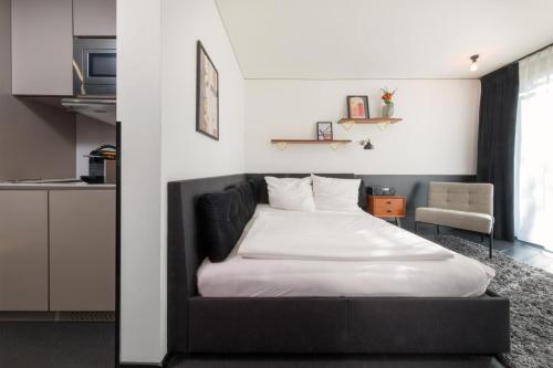 a bedroom with a bed and a chair at Brera Serviced Apartments Munich Schwabing in Munich