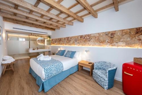 a bedroom with a large bed and a stone wall at Hotel S'Antiga Adults Only in Es Mercadal