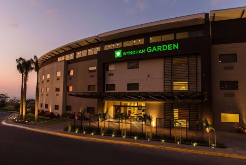 un edificio de hotel con un cartel que lee jardín universitario en Wyndham Garden San Jose Escazu, Costa Rica, en San José