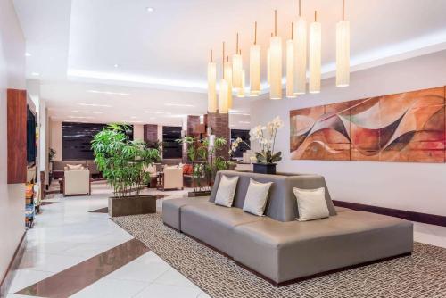 a living room with a couch and a chandelier at Wyndham Garden San Jose Escazu, Costa Rica in San José