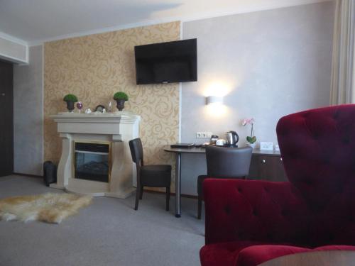 a living room with a fireplace and a tv on the wall at Landhaus "Am Sonnenberg" in Diekholzen