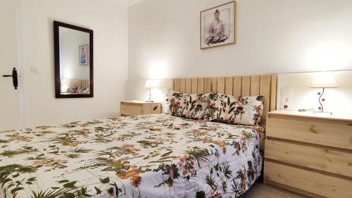 una camera da letto con un letto con copriletto floreale di Alameda Boho Chic a Siviglia