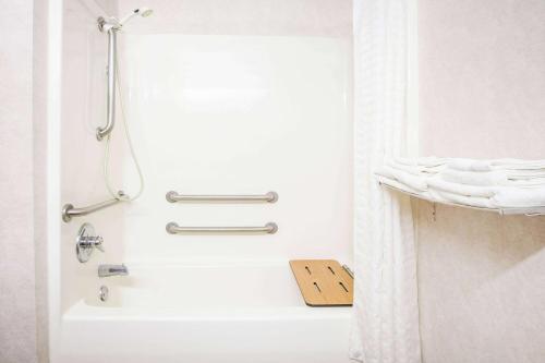 ein Badezimmer mit einer Dusche und einer weißen Badewanne in der Unterkunft Super 8 by Wyndham White Hall in White Hall