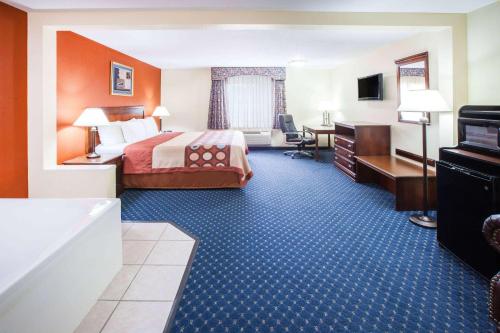 a hotel room with a bed and a bathroom at Super 8 by Wyndham White Hall in White Hall