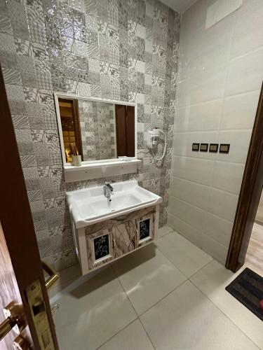 a bathroom with a sink and a mirror at Leen Serviced Apartments in Khamis Mushayt