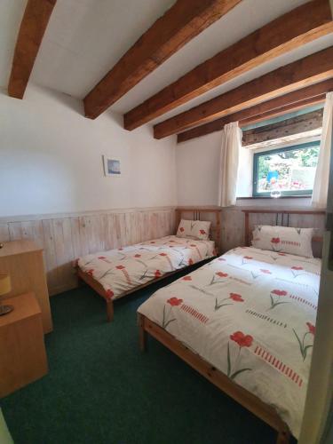 une chambre avec deux lits et une fenêtre dans l'établissement Gîte du Nouveau Monde, à Langoëlan