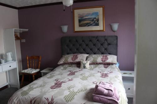 a bedroom with a bed with a purple wall at Celicall in Ballater