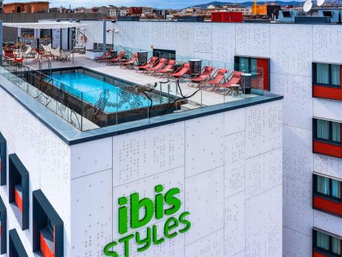 a hotel with a swimming pool on top of a building at ibis Styles Barcelona City Bogatell in Barcelona