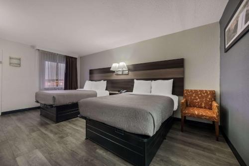 um quarto de hotel com duas camas e uma cadeira em Quality Inn Gadsden - Attalla em Gadsden