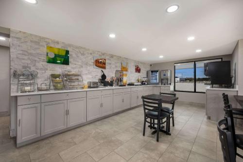 a kitchen with white cabinets and a table and a television at Quality Inn Gadsden - Attalla in Gadsden