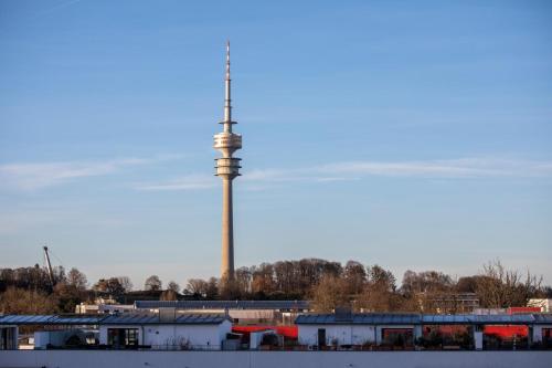 a tv tower in the distance with buildings in the foreground at Brera Serviced Apartments Munich Schwabing in Munich