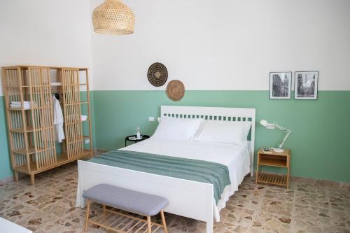 1 dormitorio con cama blanca y pared verde en Villa Ravanica en Marina di Ragusa