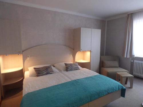 a bedroom with a large bed and a chair at Landhaus "Am Sonnenberg" in Diekholzen