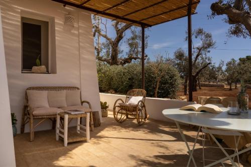 um pátio com uma mesa, cadeiras e uma mesa em Sikalindi Apulian Farm&Living em Gagliano del Capo
