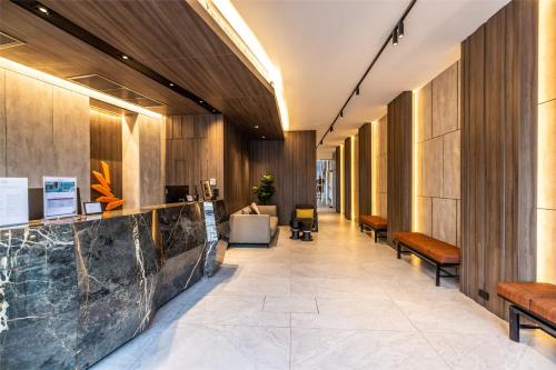 um corredor com paredes e bancos de madeira num átrio em Citrus Patong Hotel by Compass Hospitality em Praia de Patong