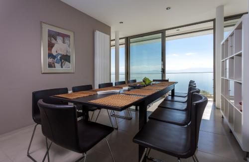 a dining room with a table and chairs and a large window at Super Luxurious Villa - 600m² - Up to 22 people in Edipsos