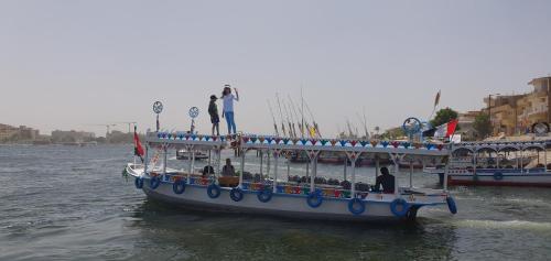 a boat with people on it in the water at Nile Sunrise Felucca Boat Private Rental in Luxor