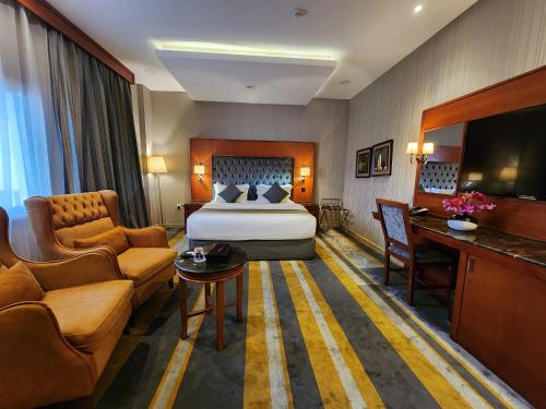 une chambre d'hôtel avec un lit et un canapé dans l'établissement Shaty Alhayat Hotel Suites, à Djeddah