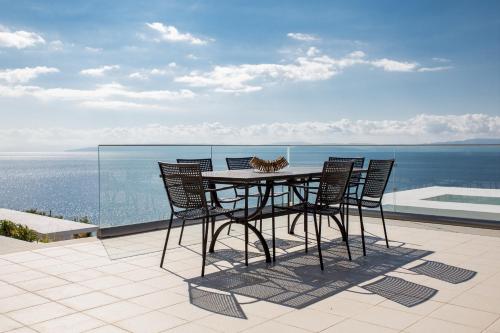 a table with a cat sitting on top of a balcony at Super Luxurious Villa - 600m² - Up to 22 people in Edipsos