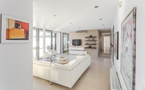 a white living room with a white couch and a tv at Super Luxurious Villa - 600m² - Up to 22 people in Edipsos