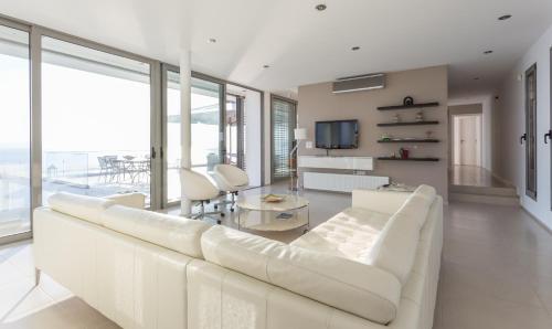 a living room with a white couch and a television at Super Luxurious Villa - 600m² - Up to 22 people in Edipsos