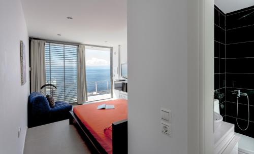 a room with a bedroom with a view of the ocean at Super Luxurious Villa - 600m² - Up to 22 people in Edipsos