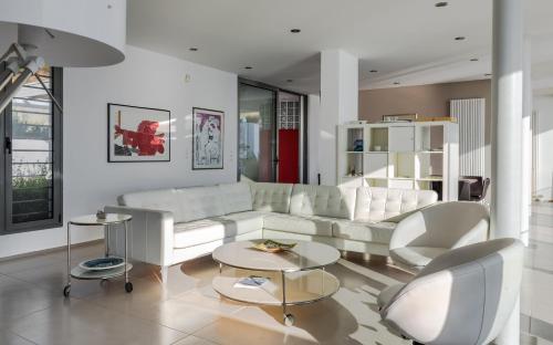 a living room with a white couch and chairs at Super Luxurious Villa - 600m² - Up to 22 people in Edipsos