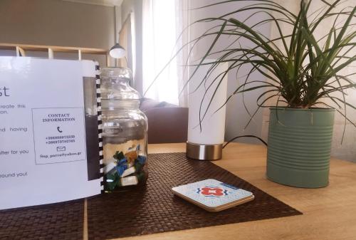 a cell phone and a bottle on a table with a plant at Xrysa's Central City Apartment in Mesolongion