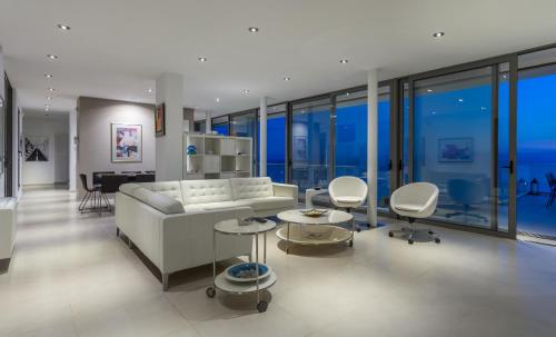 a living room with a white couch and chairs at Super Luxurious Villa - 600m² - Up to 22 people in Edipsos