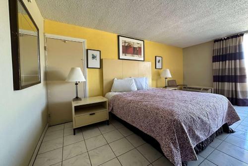 a hotel room with a bed and two lamps at Travelodge by Wyndham Lumberton in Lumberton