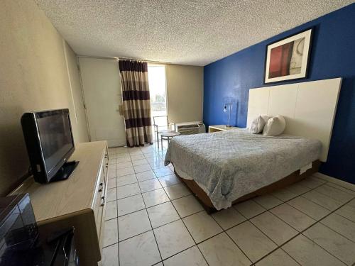a bedroom with a bed and a flat screen tv at Travelodge by Wyndham Lumberton in Lumberton