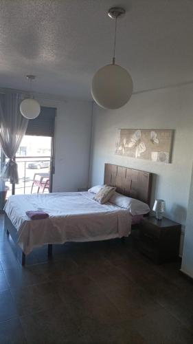 a bedroom with a large bed and two pendant lights at Apartamento Jean Pool in Alcantarilla