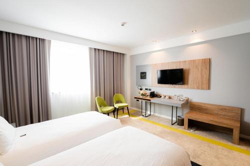 a hotel room with two beds and a desk at Mandachi Hotel & SPA in Suceava