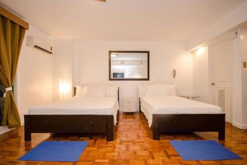 two beds in a room with blue mats at Poblacion Studio Makati Pili Suite 1BR 47sqm in Manila