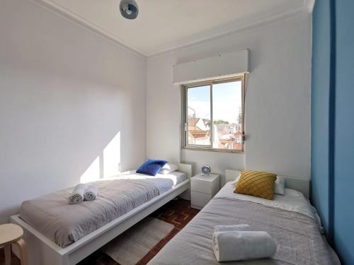 een slaapkamer met 2 bedden en een raam bij Fonte Park in Setúbal