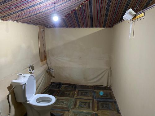 a bathroom with a toilet and a tile floor at Wadi Rum Khalid luxury camp in Wadi Rum