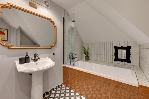 a bathroom with a sink and a bath tub at Downtown Apartments The Love Bridge - Na Piaskach in Gdańsk