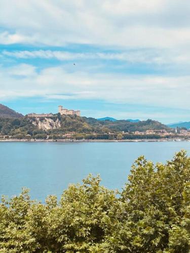 a large body of water with a castle on a hill at Babalù Con vista lago in Arona