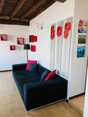 a living room with a blue couch and red pillows at Babalù Con vista lago in Arona