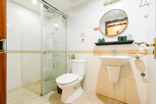 a bathroom with a shower and a toilet and a mirror at Sun Clover Boutique Hotel in Hanoi