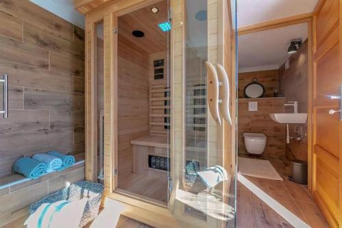 a sauna with a glass shower in a wooden bathroom at Villa LULU with heated pool, sauna & hot tub in Labin