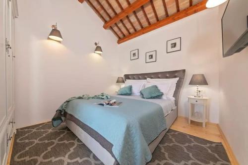 1 dormitorio con 1 cama con manta azul en Villa LULU with heated pool, sauna & hot tub en Labin