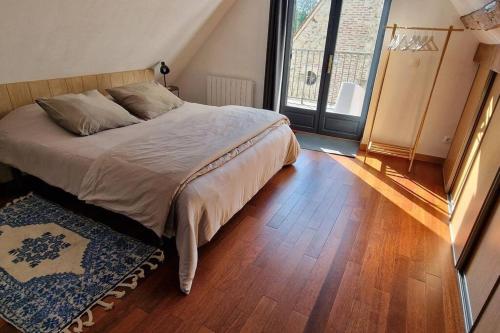 una camera con letto e pavimento in legno di Jardins de Mélusine - Maison en pierres 